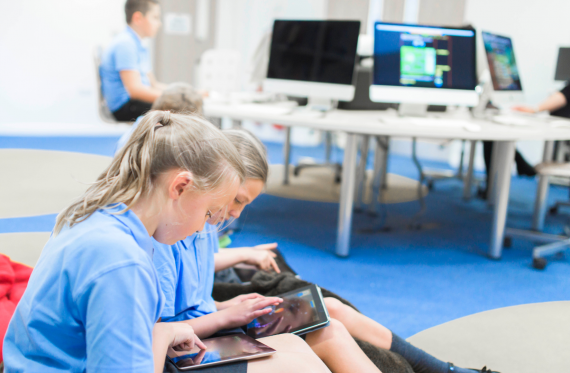 two students on tablets at school