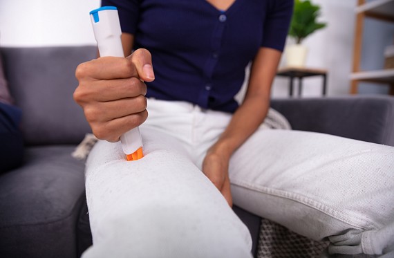 Person injects AAI into leg following allergic reaction.