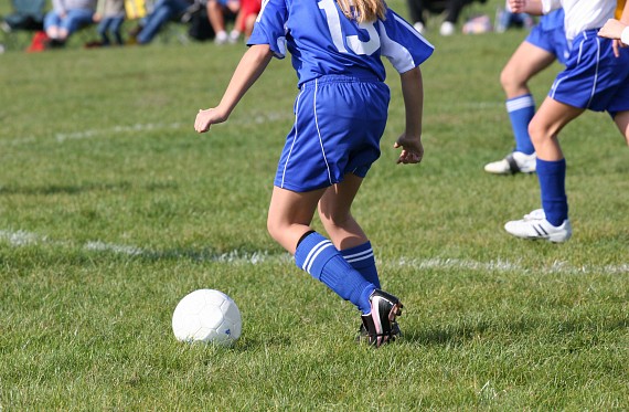 A young girl playing football