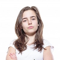 A teenager with arms folded.