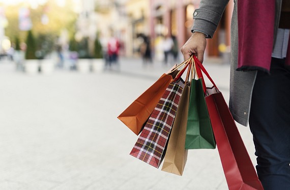 A person with shopping bags walking along a high street