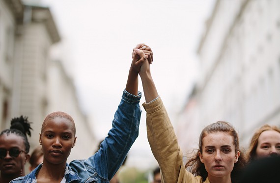 Two women holding hands powerfully