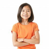 a young child folding her arms and smiling