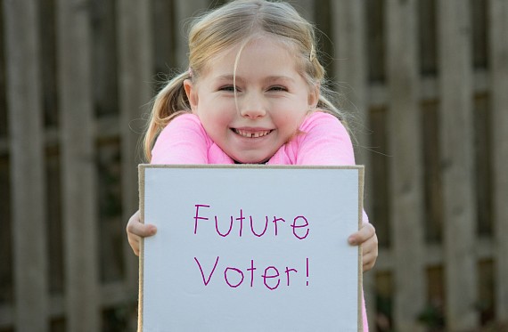 Child holding a sign that says 'Future Voter'