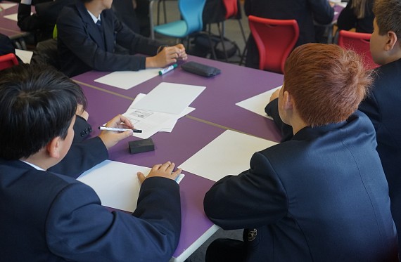 secondary school pupils using whiteboards at their tables