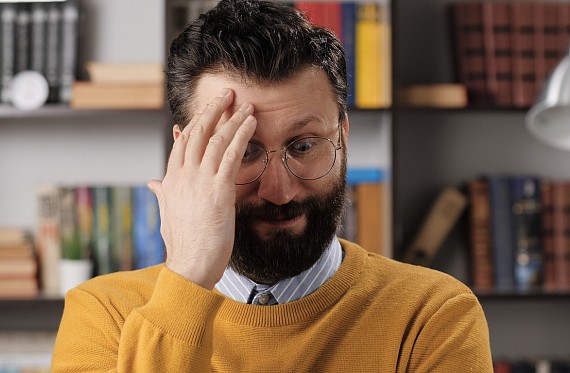 teacher holding hand to head looking overwhelmed/confused/stressed