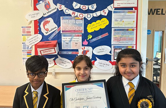 Godolphin Young Writers for VotesforSchools with their certificate, in front of a VotesforSchools display