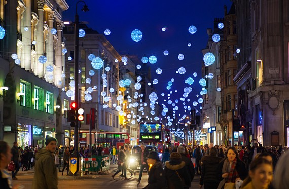 A busy city with festive decorations hanging in the air.