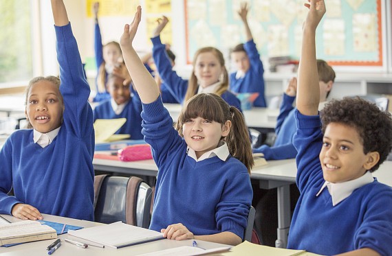 Children in class hands up