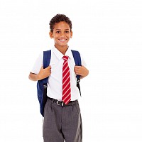 young primary aged pupil in school uniform with backpack