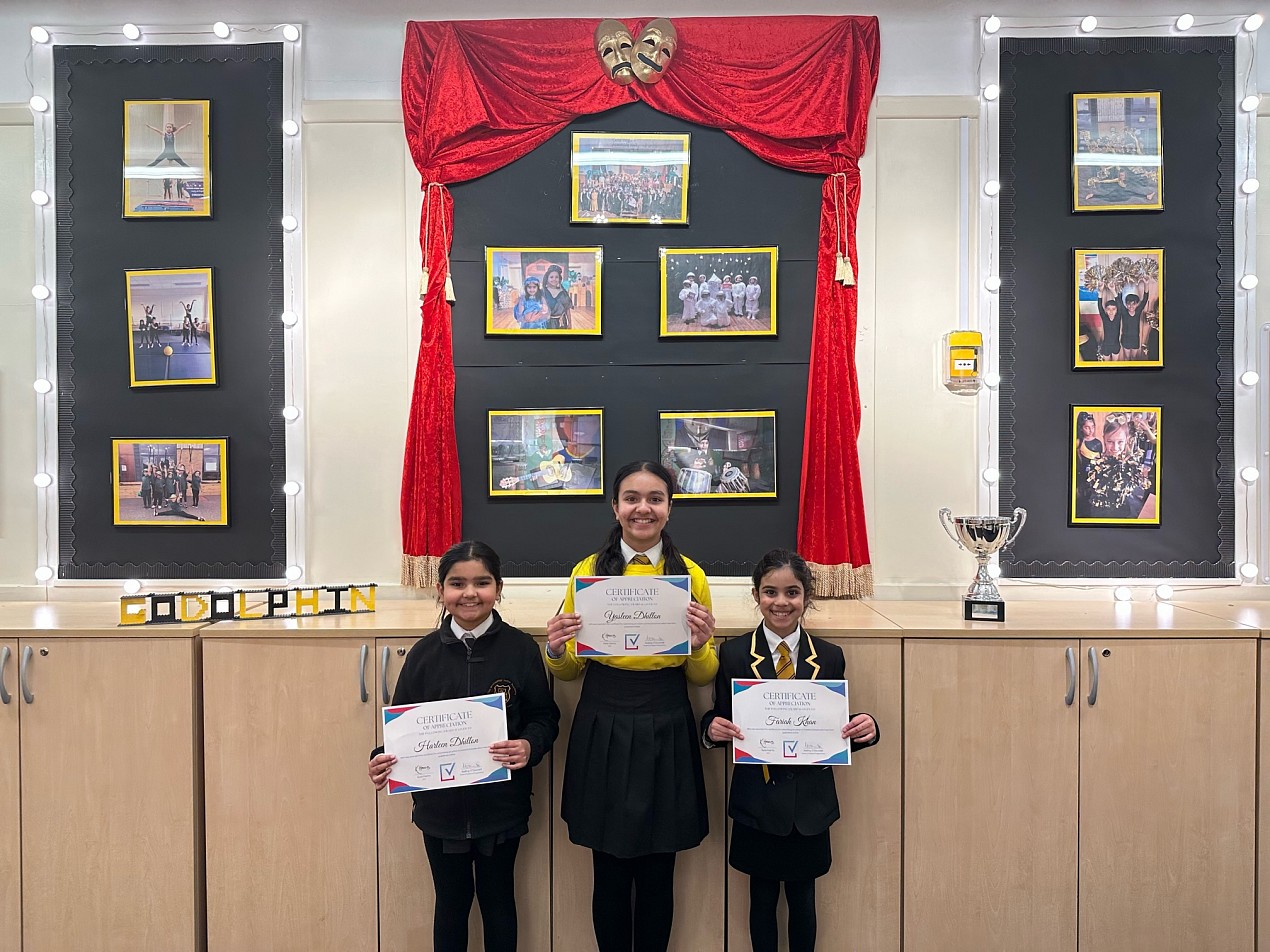 Fariah, with two peers, holding a certificate from VotesforSchools at Godolphin Juniour Academy