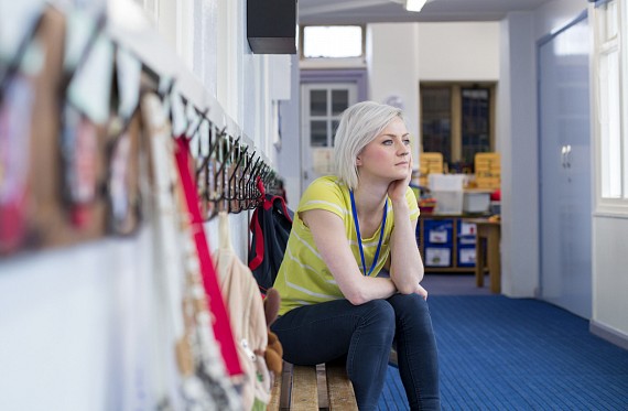 Stressed teacher in school thinking about assembly