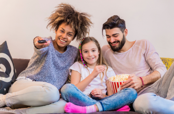 Family sitting down to watch TV together