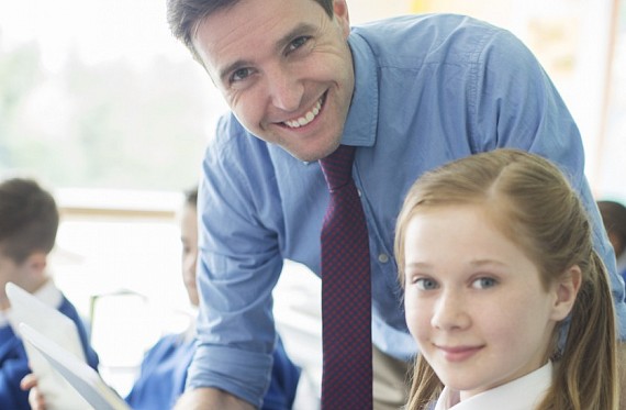 Teacher supporting pupil in school council