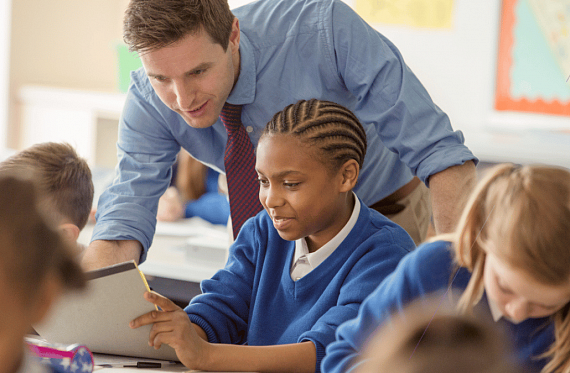 teacher helping young child at school