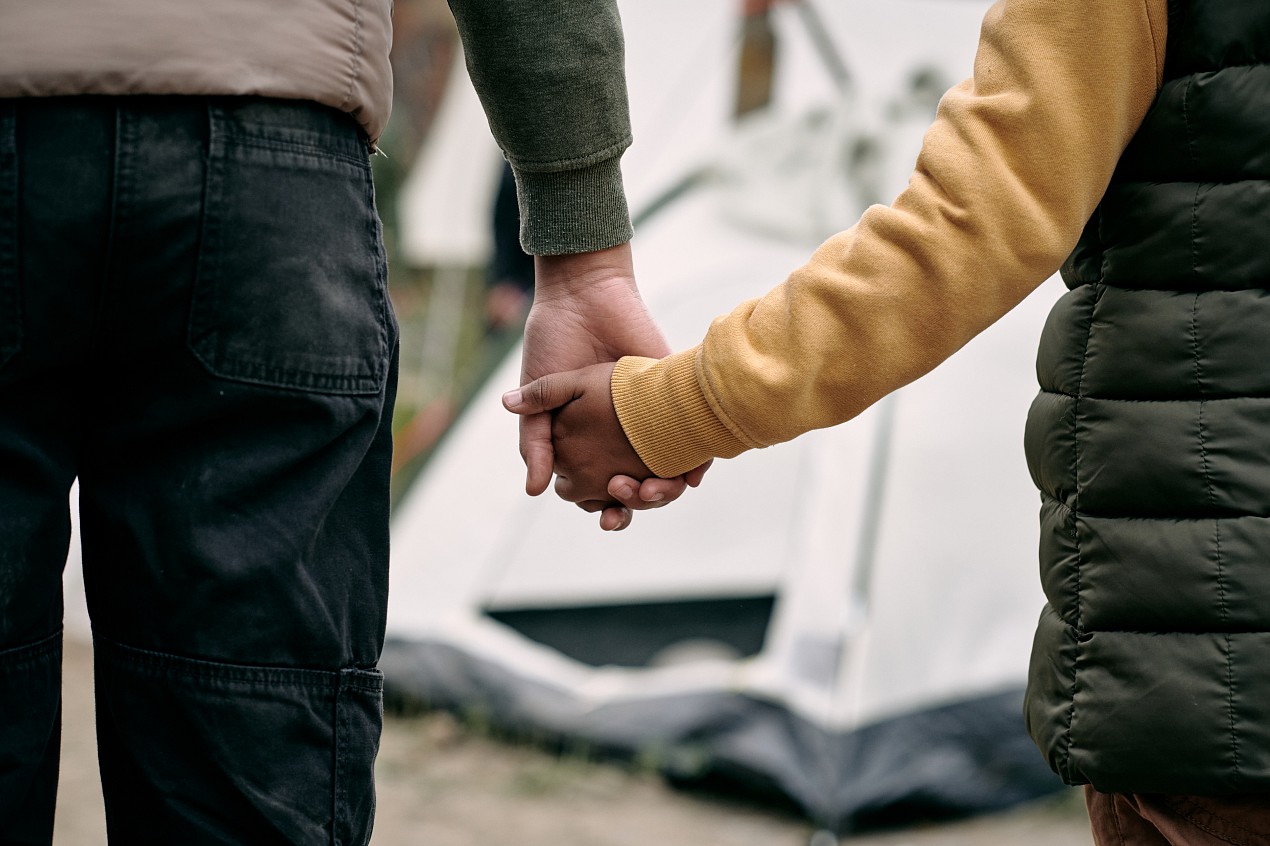 two people seeking refuge holding hands