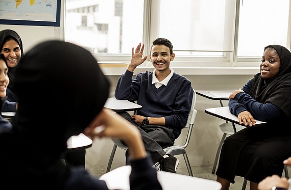 Young person with hand up in class