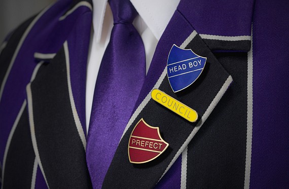 child in uniform with school council badges on blazer